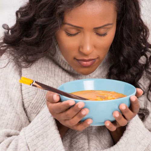 Woman smelling her soup
